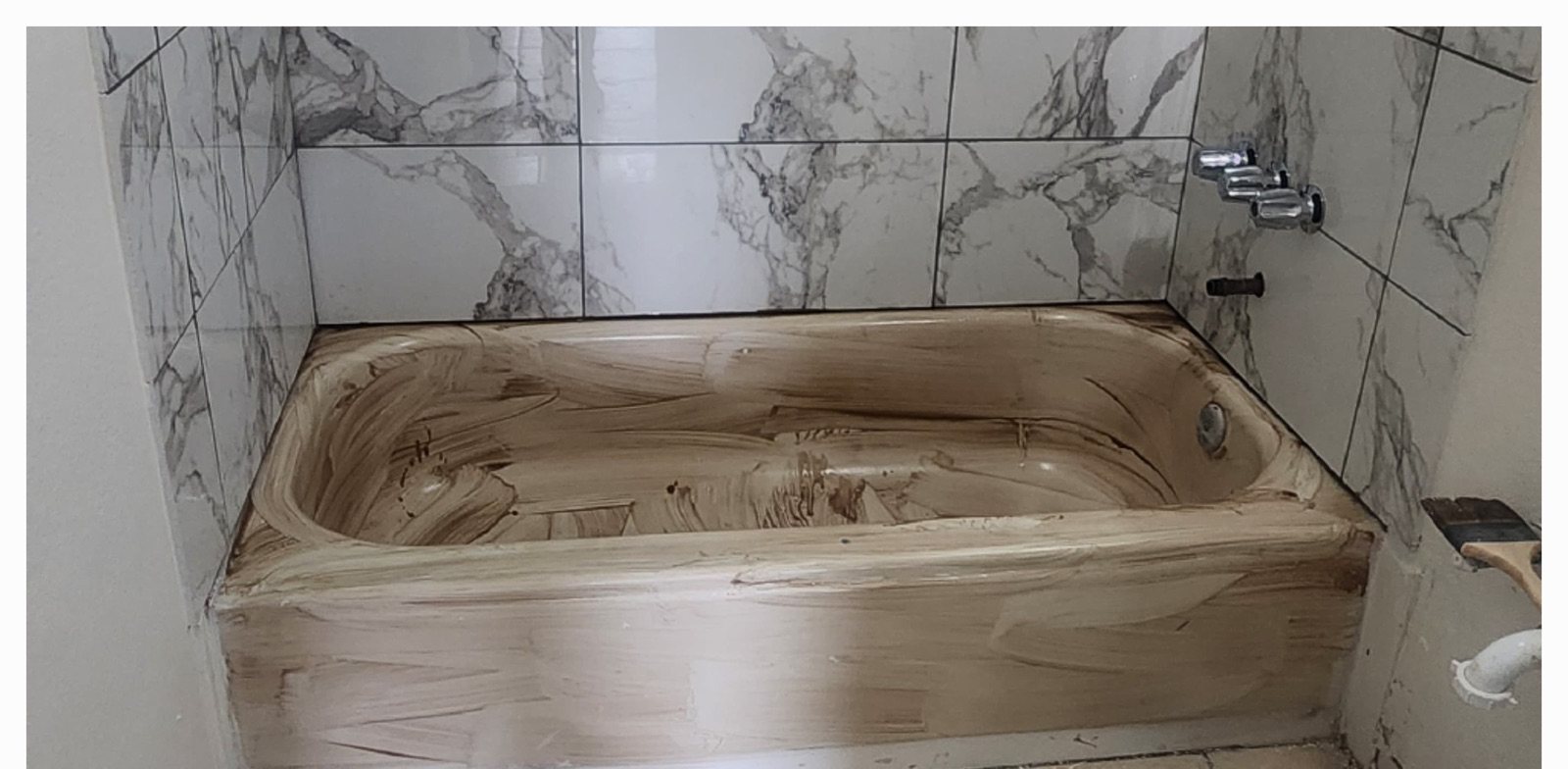 Before: bathtub refinished in a marble tile surround in Corona